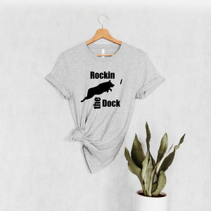 light grey shirt with a design that Says 'Rockin the Dock' with an Australian Shepherd jumping after the bumper/toy