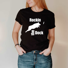 Load image into Gallery viewer, black t- shirt with a design that Says &#39;Rockin the Dock&#39; with an Australian Shepherd jumping after the bumper/toy