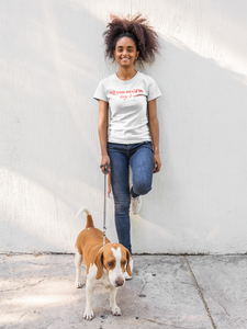 A girl wearing a white shirt that reads ' all you need is dogs & wine'